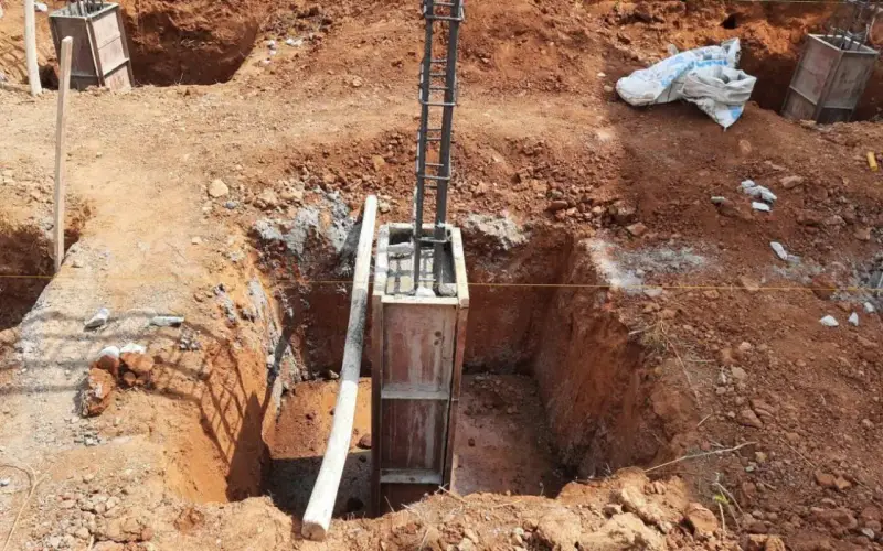 Wykop pod fundament słupowy, zbrojenie i szalunek gotowe do zalania betonem.