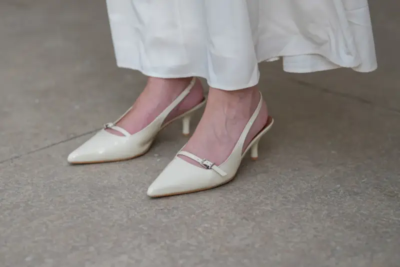 Eleganckie, kremowe szpilki z paskiem na pięcie, idealne do letnich sukienek. Niewidoczne skarpetki do szpilek zapewniają komfort.