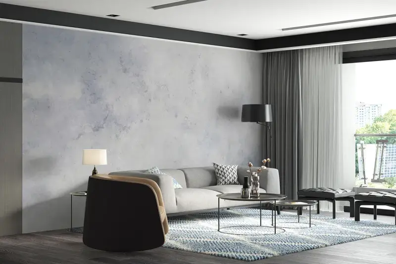 Nowoczesny salon z szarą sofą i fotelem. W tle efektowny **beton na ścianie**, który nadaje wnętrzu industrialnego charakteru.