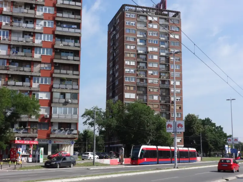 Wielopiętrowe budynki mieszkalne i nowoczesny tramwaj na ulicy. Czy w Belgradzie jest bezpiecznie? Wygląda na spokojne miasto.