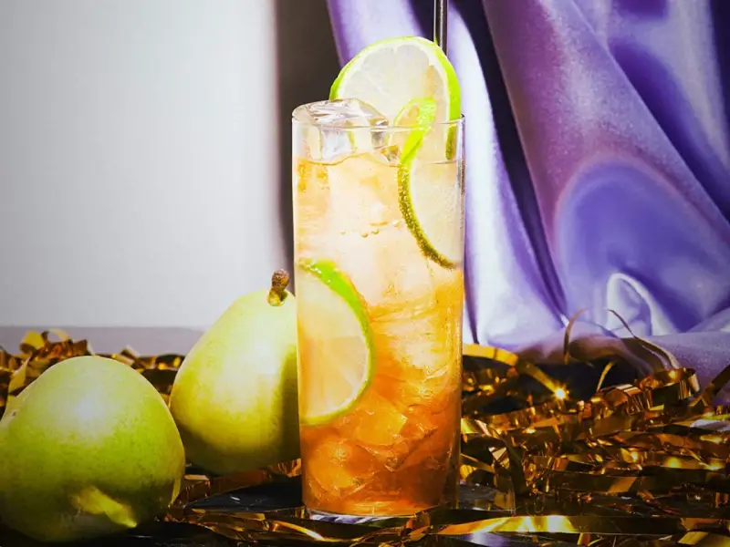 Lennart drink med päron och lime, serverad med is och gyllene konfetti.