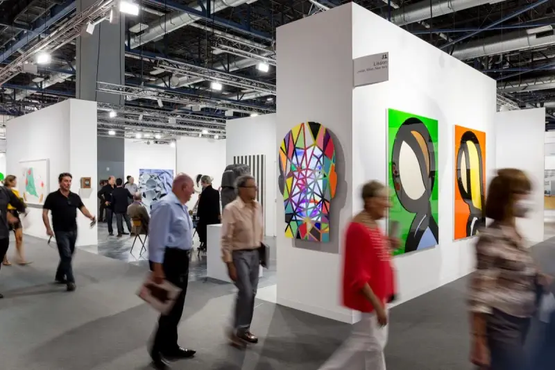 Visiteurs déambulant dans une foire d'art, découvrant des œuvres colorées et des sculptures. On y voit comment fonctionne une galerie d'art : présentation, exposition et interaction.