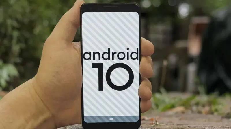 Dłoń trzyma smartfon z logo android 10 na ekranie.