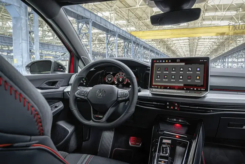 Wnętrze samochodu Volkswagen Golf z dużym ekranem dotykowym i cyfrowymi zegarami.