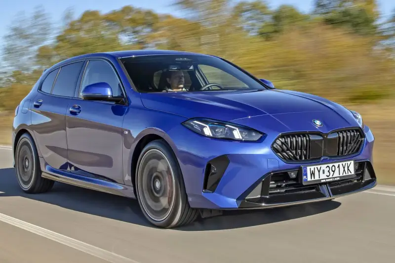 Niebieskie BMW serii 1 (f21) w ruchu, z kierowcą za kierownicą.