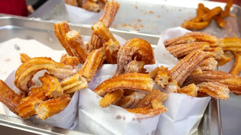 Deliciosos churros recién hechos, cubiertos de azúcar. Una guía visual de como hacer churros perfectos.