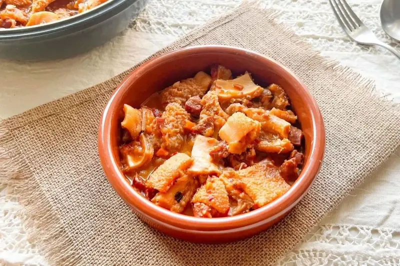 Un cuenco de barro con callos a la vizcaina, un plato tradicional español lleno de sabor y textura.