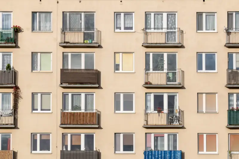 Façade d'immeuble avec de nombreux balcons et fenêtres, offrant un aperçu de la vie quotidienne et du **logement décent**.