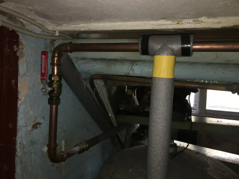 Kopparrör med isolering och en röd ventil, redo att fylla på luft i hydrofor.