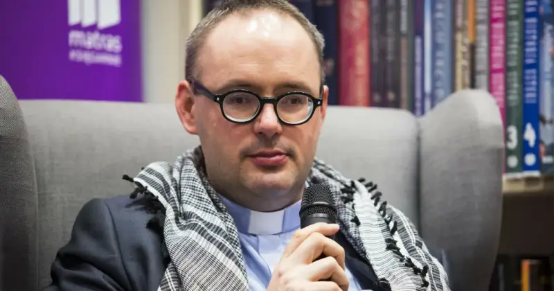 Ksiądz Kaczkowski, w okularach i z szalem, dzieli się cytatami o życiu.