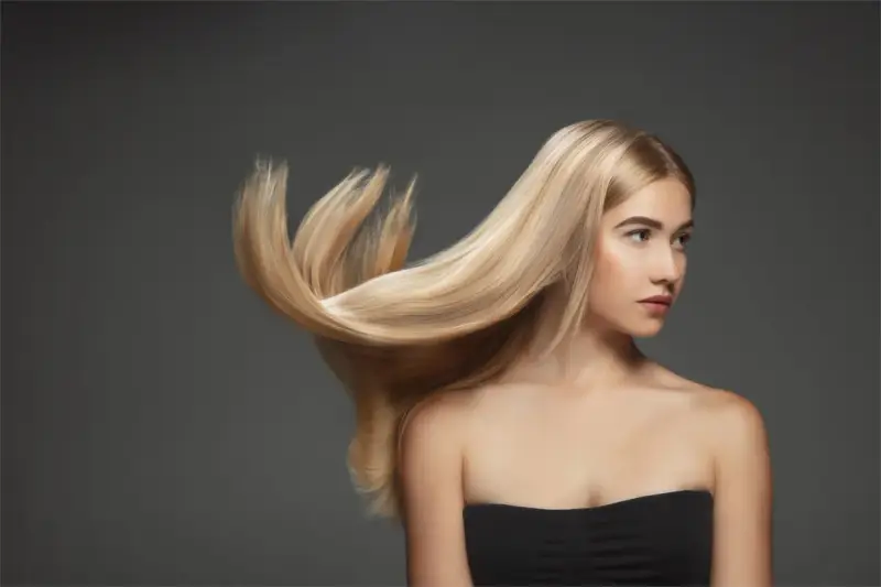 Blond włosy modelki falują, ukazując ich zdrową budowę.