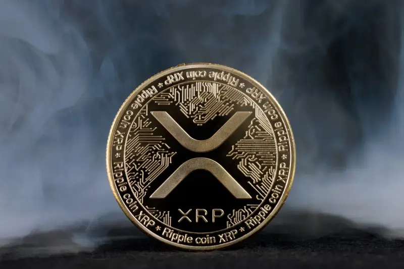 Złoty token kryptowaluty XRP, otoczony mgłą, symbolizuje przyszłość finansów.