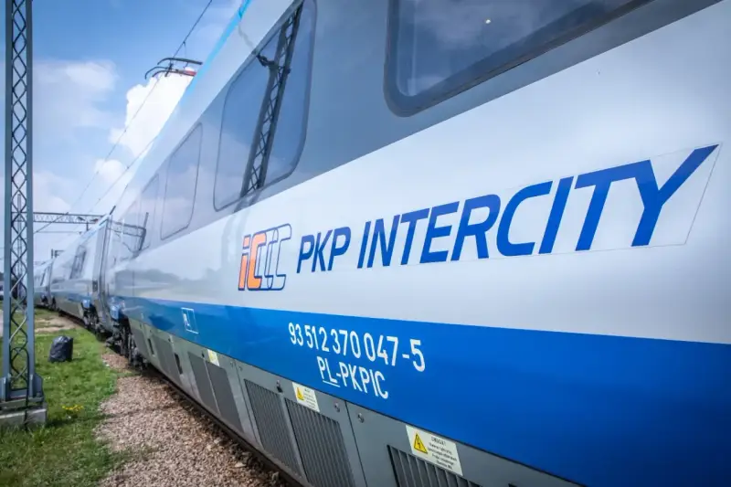Pociąg PKP Intercity z niebieskim pasem i logo.