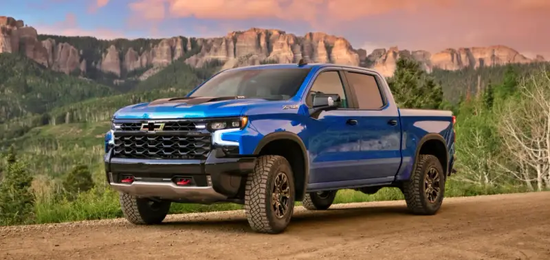 Niebieski Chevrolet pickup ZR2 na drodze w górach, gotowy na przygodę.