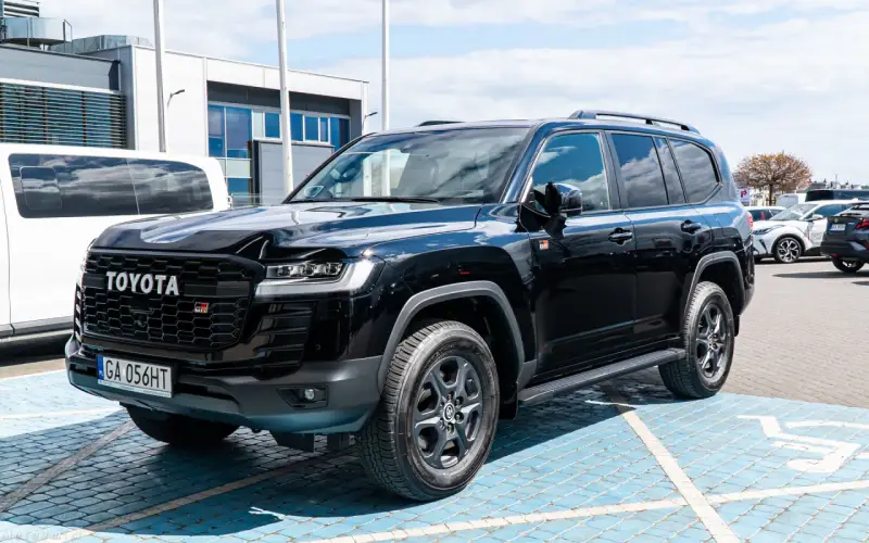 Czarny Toyota Land Cruiser 300 GR Sport z grillem w kształcie plastra miodu i oznaczeniem GR.