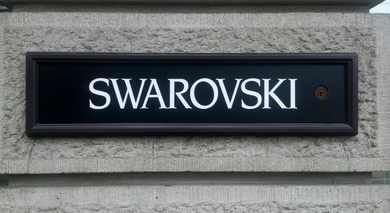 Tablica z napisem SWAROVSKI, symbolizująca luksus i precyzję, przypomina o austriackich korzeniach marki.