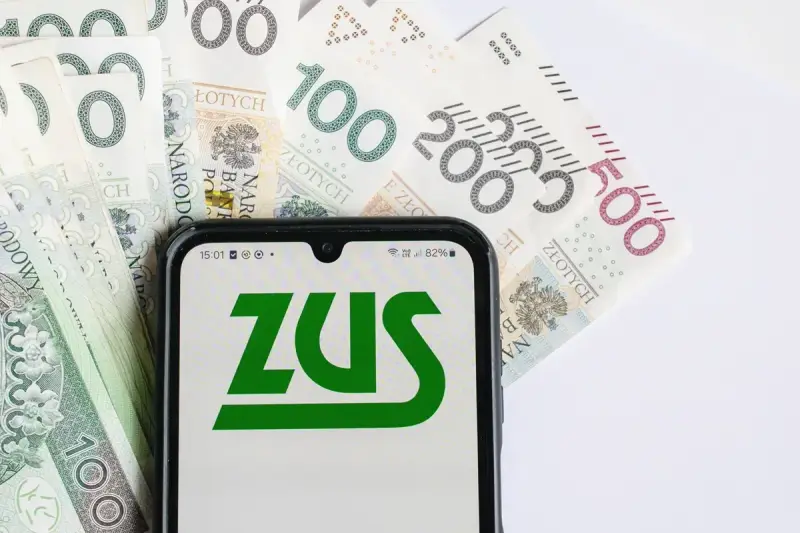 Na ekranie telefonu widnieje logo ZUS, a w tle polskie banknoty. Wszyscy zastanawiają się, kiedy będzie wypłacana trzynastka.
