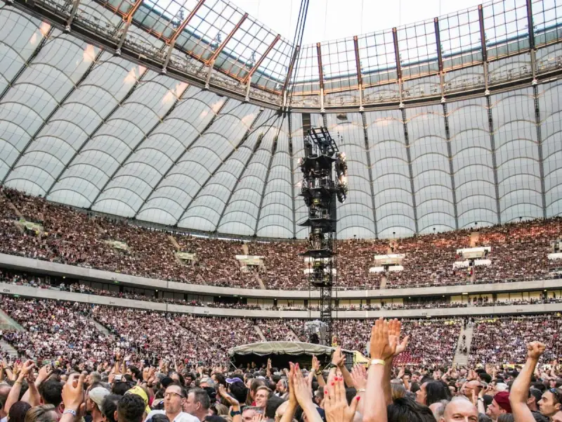 Roztanczony PGE Narodowy w Warszawie, tłumy ludzi na koncercie pod dachem stadionu.