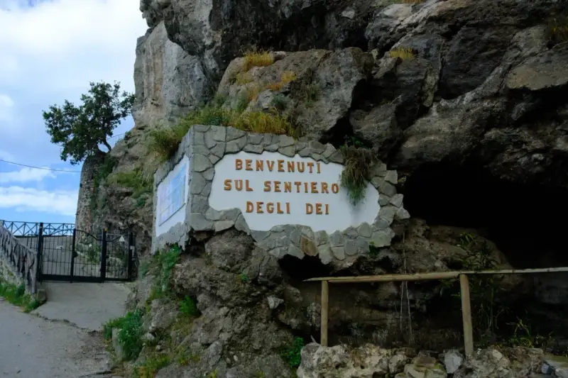 Ingresso del Sentiero degli Dei, con cartello di benvenuto e cancello in ferro battuto.