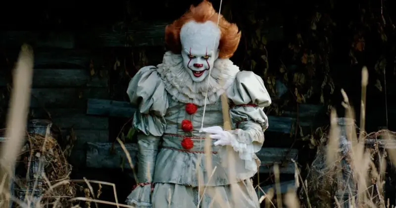 Przerażający klaun Pennywise, znany z horrorów Netflix, wychodzi z mroku.