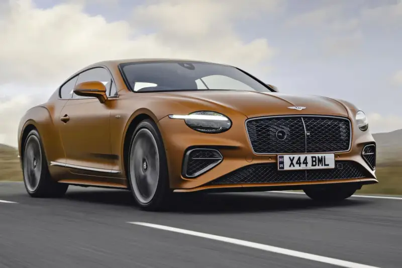 Pomarańczowy Bentley Continental GT na drodze. Sprawdź aktualną bentley cena i poczuj moc.
