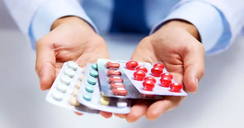 Hände halten Blisterpackungen mit Medikamenten. Möglicherweise zur Linderung von Nervenschmerzen.