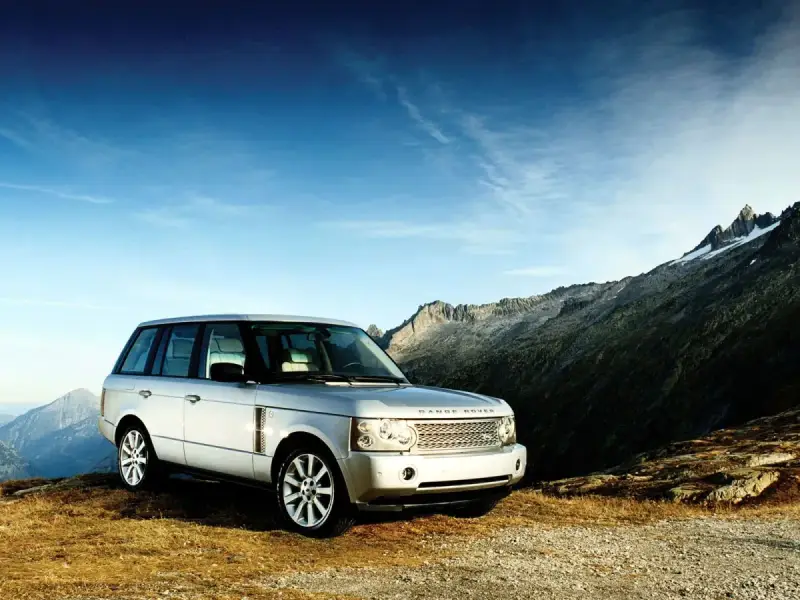 Srebrny Range Rover Vogue na tle górskich szczytów. Gotowy na każdą przygodę.