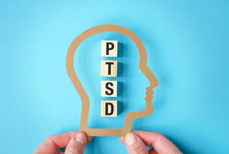 W głowie z papieru litery P, T, S, D układają się w słowo PTSD, symbolizując jego objawy.