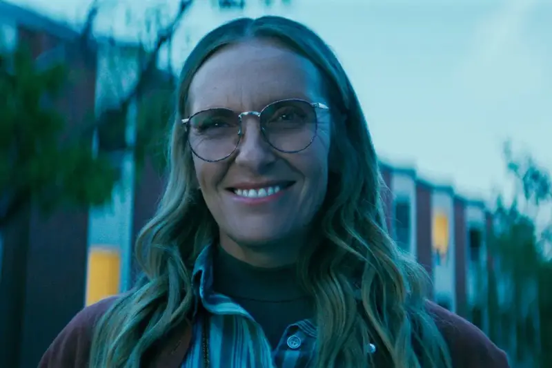 Uśmiechnięta Toni Collette w okularach, znana z wielu filmów i seriali, wygląda na zadowoloną.