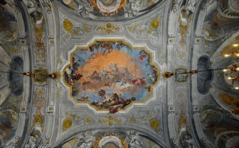Plafond orné de fresques célestes, un exemple de style **rococo def.**, avec des anges, des chevaux et un soleil éclatant.