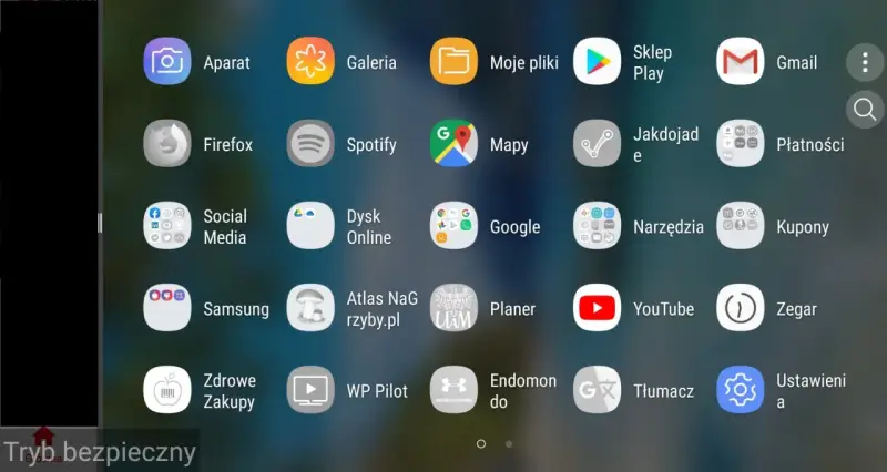 Ekran telefonu z ikonami aplikacji. Widoczny jest pasek "Tryb bezpieczny", co sugeruje, jak włączyć tryb awaryjny w telefonie.