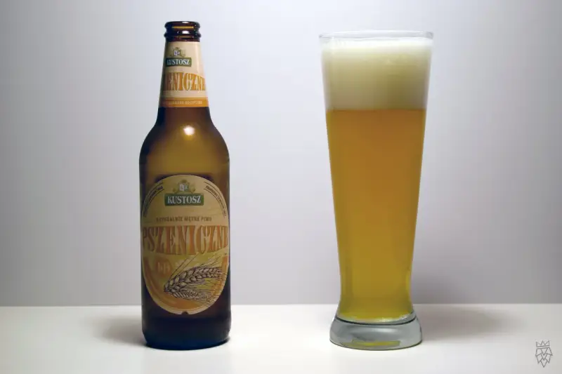 Kustosz piwo pszeniczne, naturalnie mętne, w butelce i szklance z obfitą pianką. Idealne na letnie popołudnie.