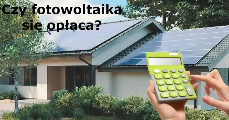Dom z panelami fotowoltaicznymi na dachu. Obok kalkulator, sugerujący opłacalność inwestycji w fotowoltaikę w domu.