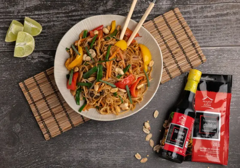 Kolorowy makaron wok z warzywami i orzeszkami ziemnymi, podany z sosami House of Asia.