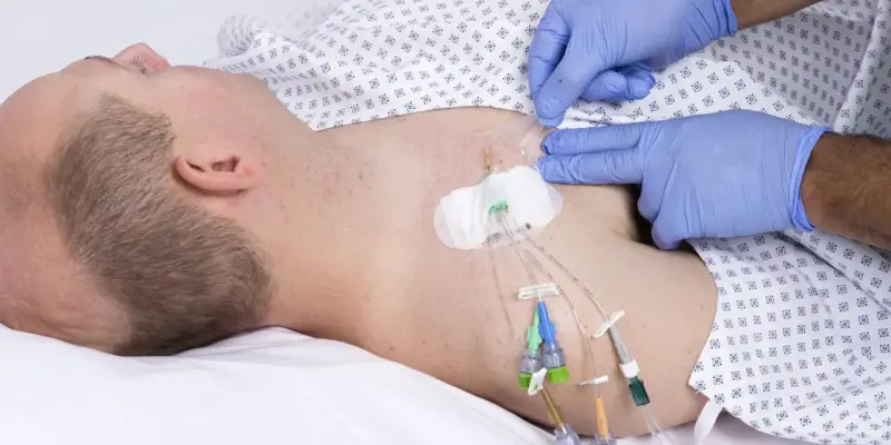 Ein Arzt mit blauen Handschuhen sichert einen zentralen Venenkatheter (pvk medizin) bei einem liegenden Patienten.
