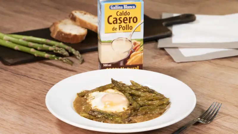 Espárragos esparragados con huevo frito, pan y caldo de pollo Gallina Blanca.