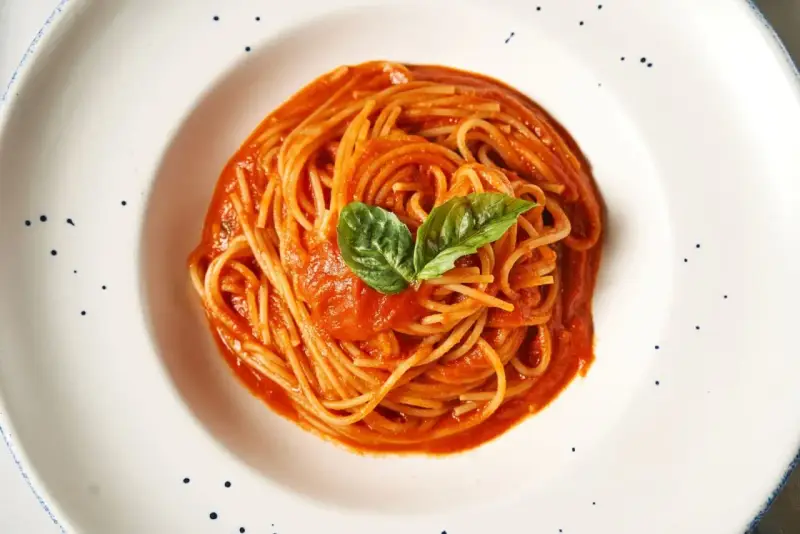 Pyszne spaghetti z sosem pomidorowym i bazylią. Prawdziwa **Italia na talerzu**, która rozpływa się w ustach.