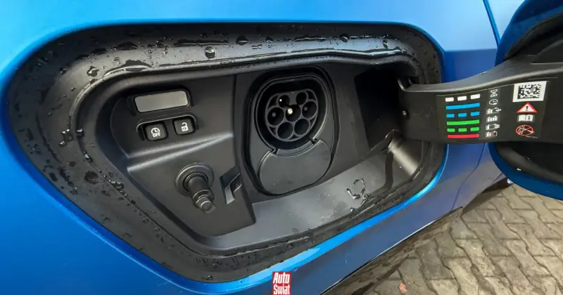 Gniazdo ładowania hybrydy plug-in z widocznymi przyciskami i ikonami.