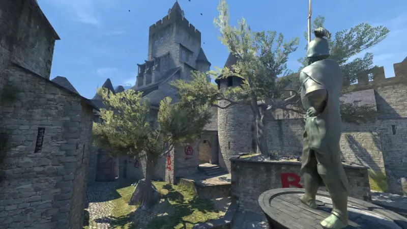 Dziedziniec zamku w CS:GO, z kamienną rzeźbą rycerza i brukowaną ścieżką.