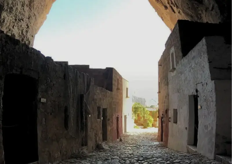 Antica via acciottolata che conduce verso il mare, incastonata nella roccia della grotta Mangiapan.