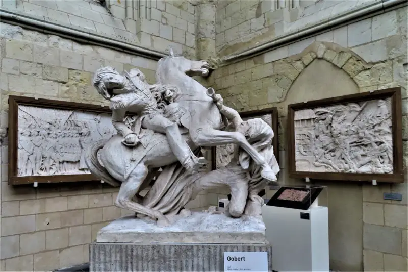Sculpture équestre de David d'Angers, un homme en uniforme militaire sur un cheval cabré, avec des bas-reliefs en arrière-plan.