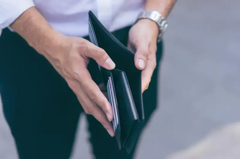 Puste ręce trzymające portfel, symbolizujące trudności finansowe i przykłady stagflacji.