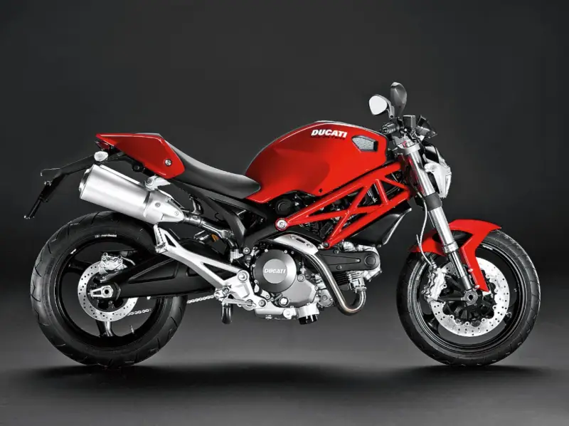 Czerwony Ducati Monster 696 z charakterystyczną kratownicową ramą, błyszczącym wydechem i sportowym siedzeniem.