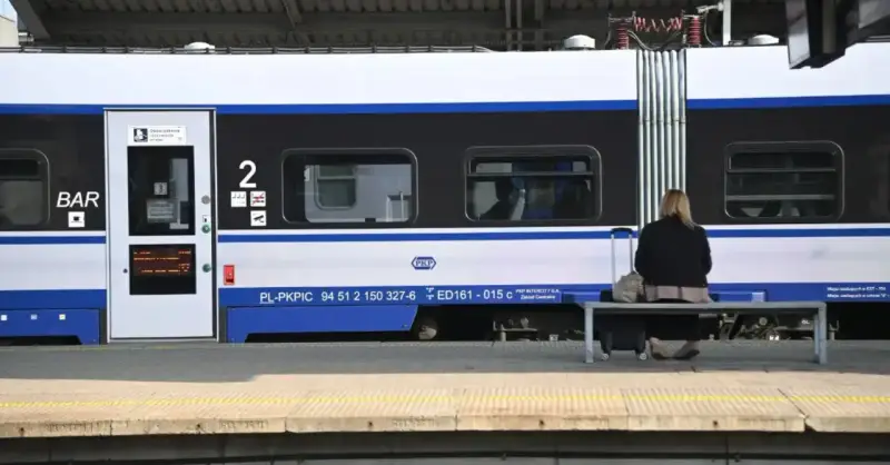 Kobieta z walizką czeka na pociąg PKP Intercity, szukając tanich biletów.