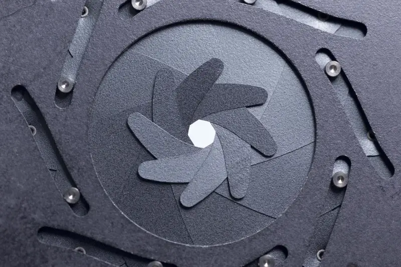 Mechanizm przysłony w aparacie fotograficznym inaczej. Widok z bliska na ruchome listki tworzące otwór.