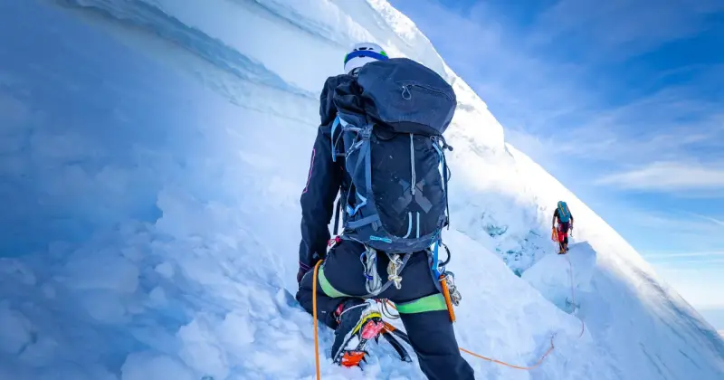Wspinaczka na szczyt w Himalajach. Dwóch alpinistów wspinających się po lodowej ścianie, wspinaczka na szczyt w Himalajach.