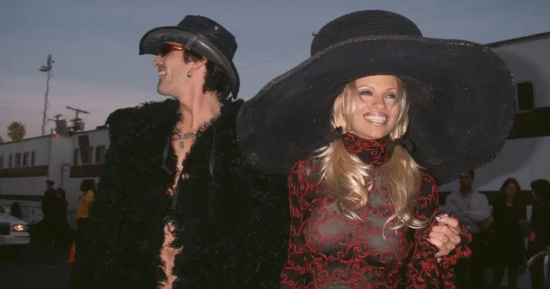 Pamela Anderson i Tommy Lee w stylizacjach z epoki. Ona w wielkim kapeluszu i wzorzystej sukience, on w kowbojskim kapeluszu i futrzanej kurtce.