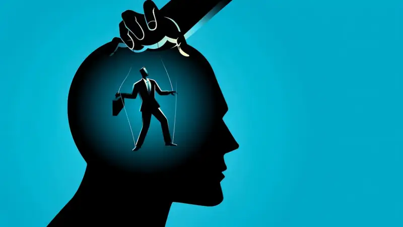 Silhouette di un uomo d'affari marionetta, mosso da fili da una mano, simboleggia la manipolazione mentale.