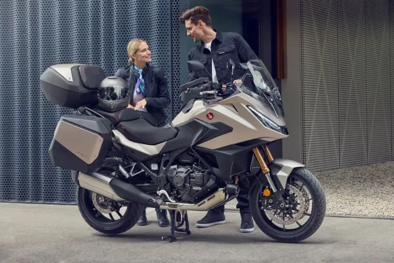 Para zwiedzająca motocykle z automatyczną skrzynią biegów. Nowoczesny design i praktyczne kufry zachęcają do wspólnych podróży.