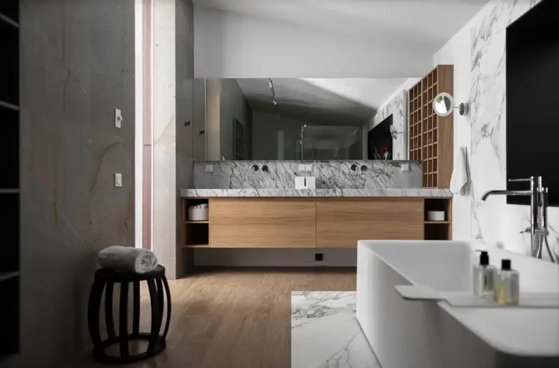 Salle de bain moderne avec meuble en bois clair, marbre et baignoire. Le bois est un excellent choix pour le meuble de salle de bain, alliant esthétique et durabilité.